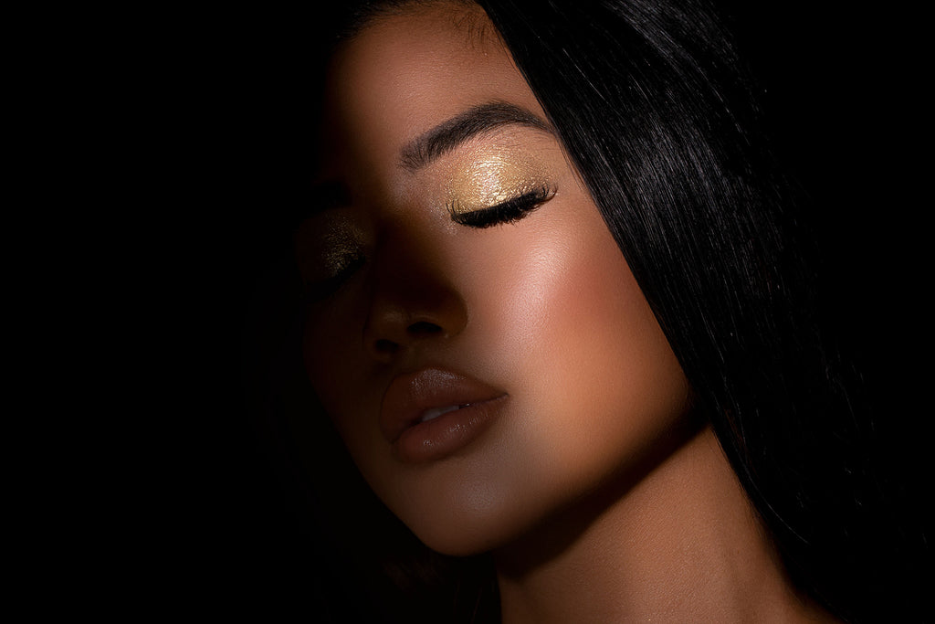 Woman wearing gold eyeshadow and nude lipstick